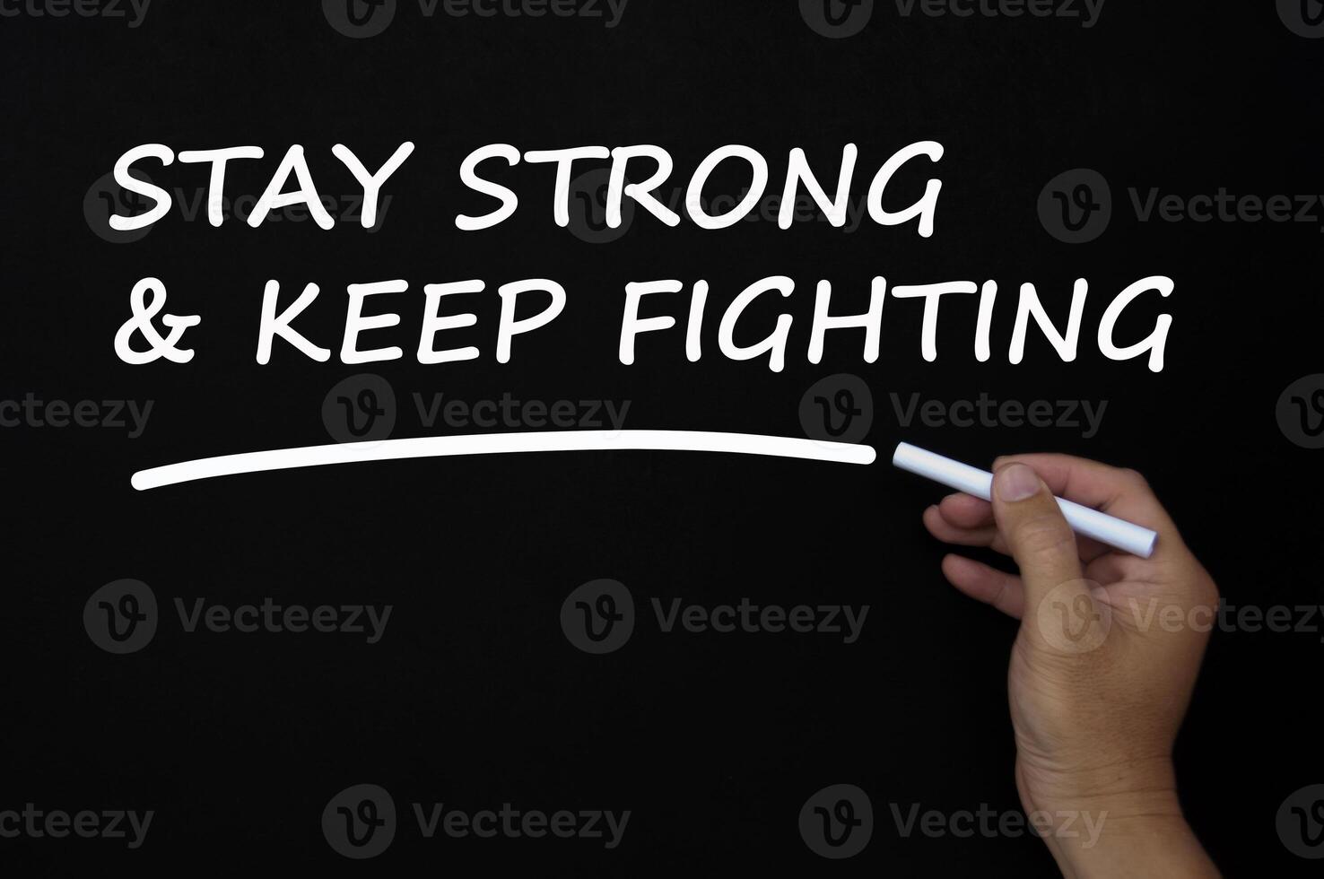 Stay strong and keep fighting text written on blackboard using chalk. photo