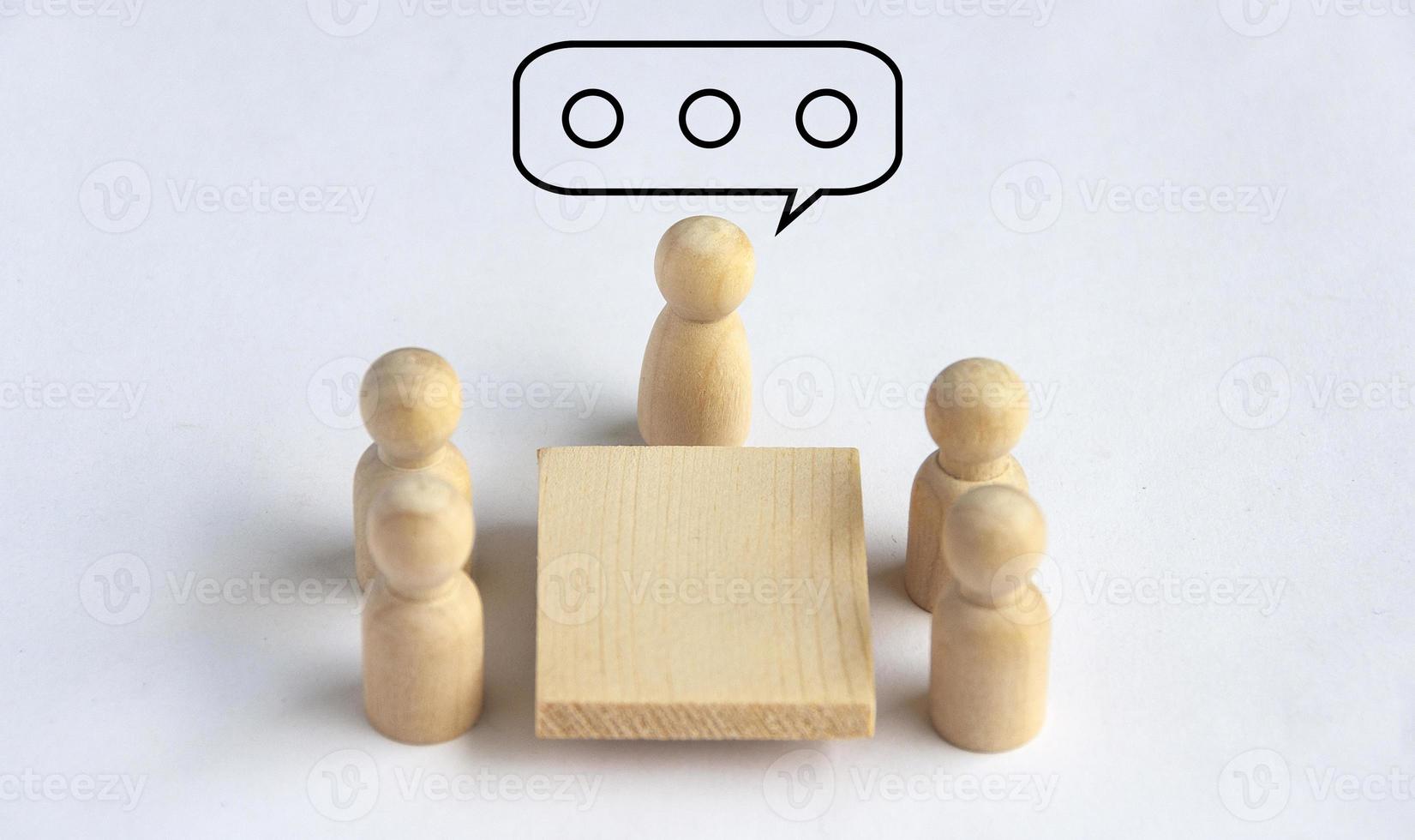 Wooden people figures having business meeting. photo