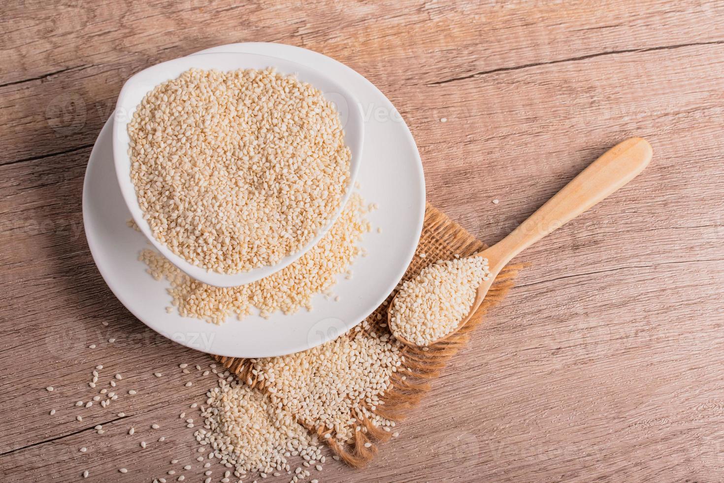 white sesame in white ceramic cup on wooden background photo