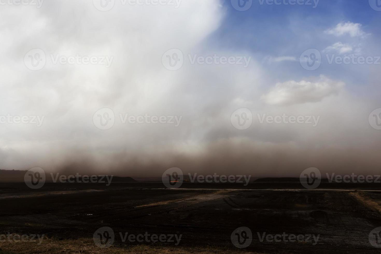 dust from peat excavations flying against the sky photo