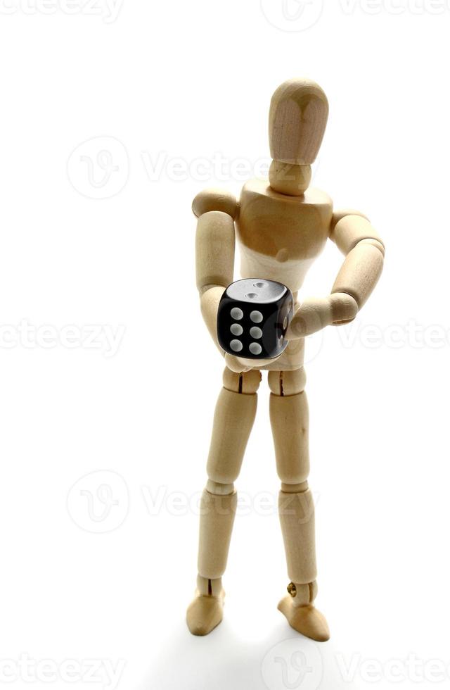 Wooden manikin holding dice photo