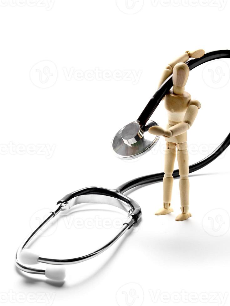 Wooden mannequin holding a stethoscope photo