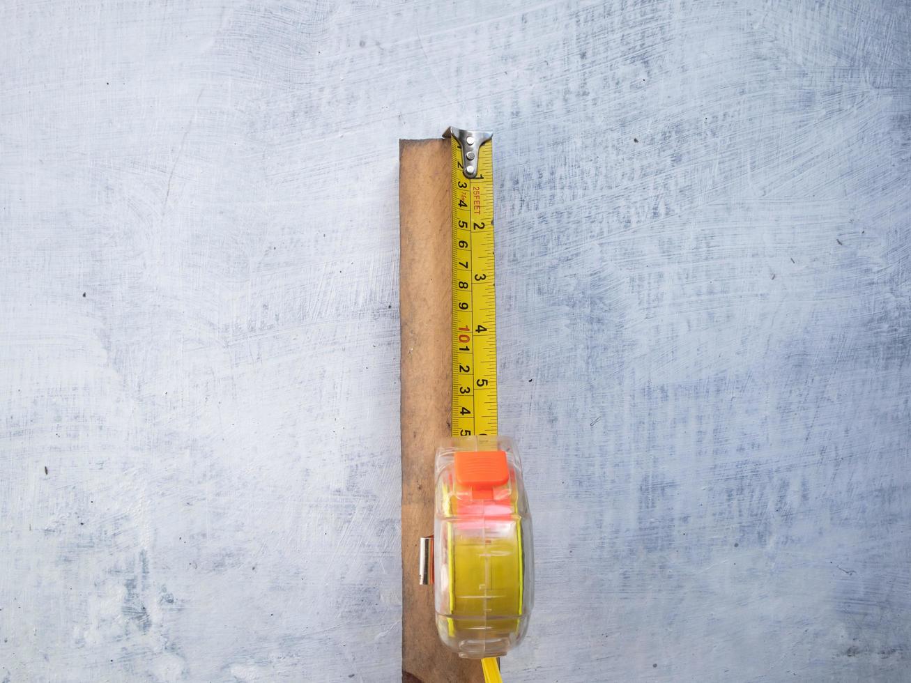 photo of a tape measure measuring a stick of wood isolated