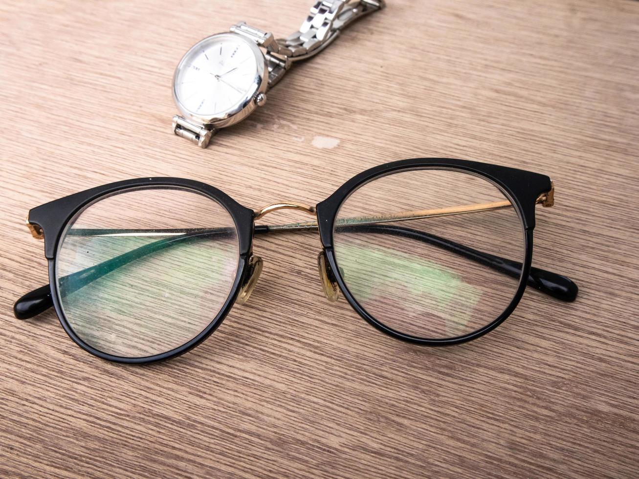 sidoarjo, jawa timur, indonesia, 2022 - foto de primer plano de gafas de diseño de mujer junto a un reloj de plata