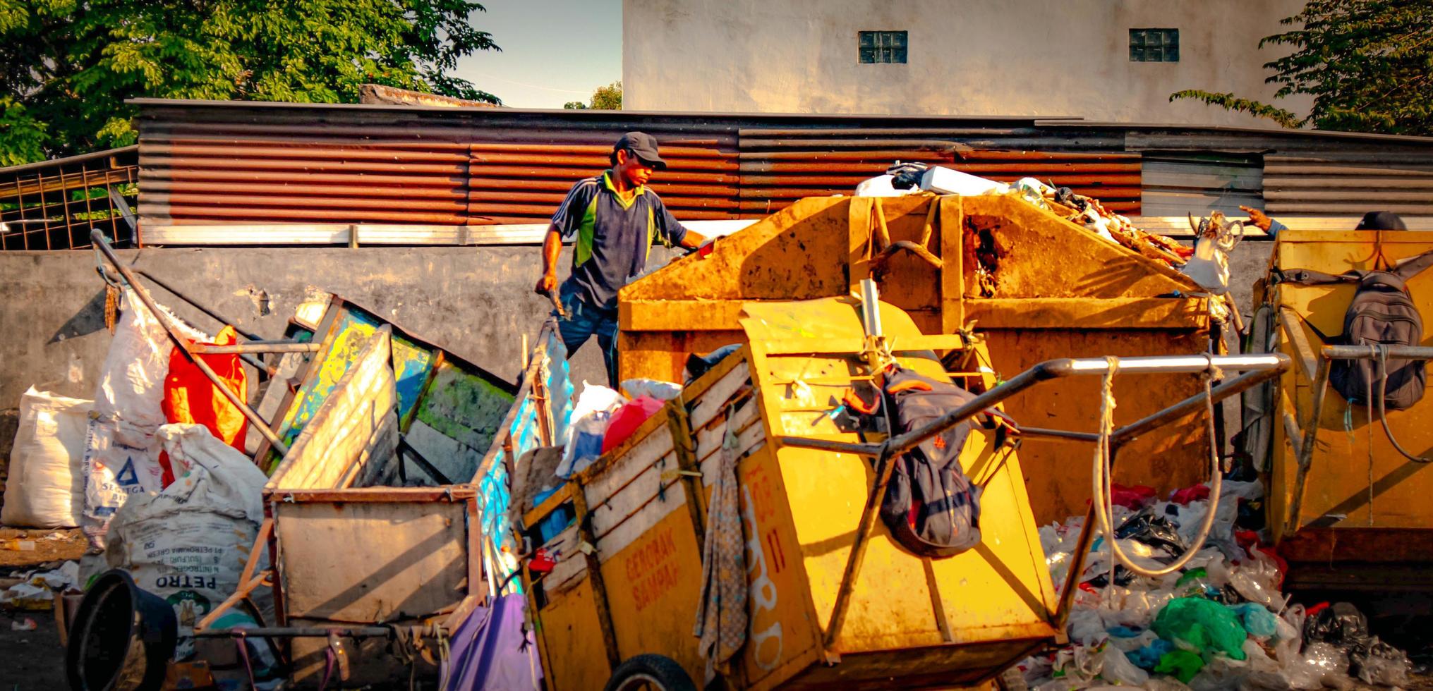 gresik, jawa timur, indonesia, 2022 - un basurero, conserje, carro de basura alrededor del complejo de viviendas foto