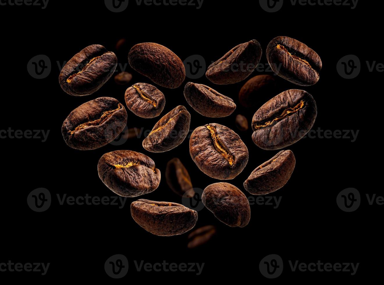 Coffee beans in the shape of a heart on a black background photo