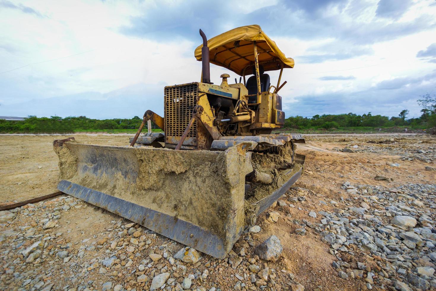 Crawler Dozer Yellow parked in a clearing in preparation for topsoil and a beautiful blue sky in the background. The concept of a bulldozer prepares the topsoil for construction. photo