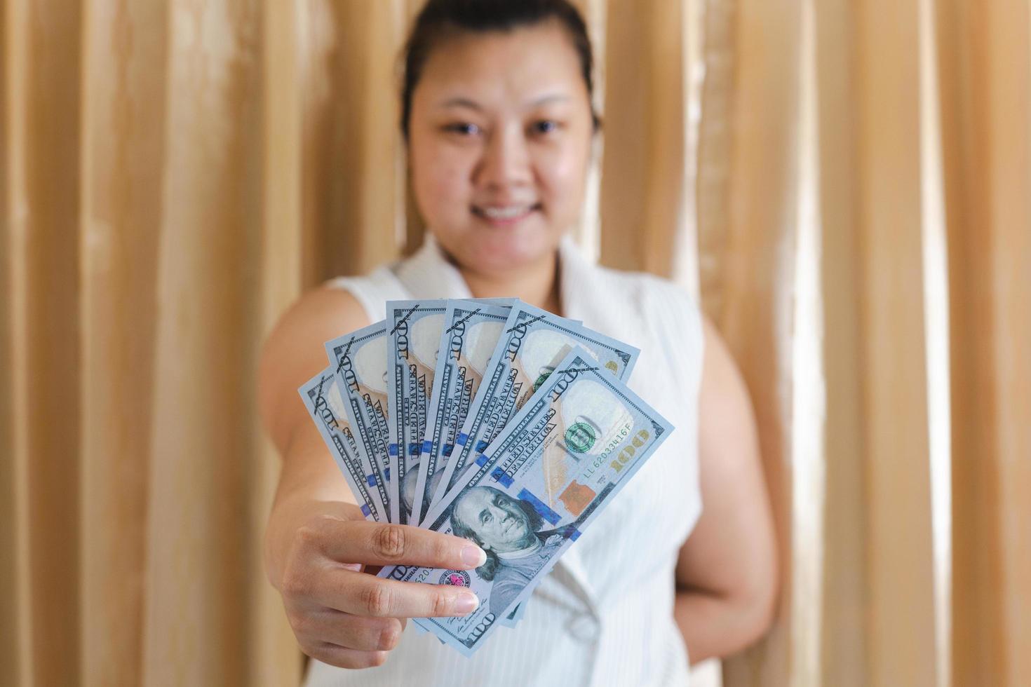 The right hand of a white woman showing a mock-up hundred-dollar banknote for shopping. selective focus. photo