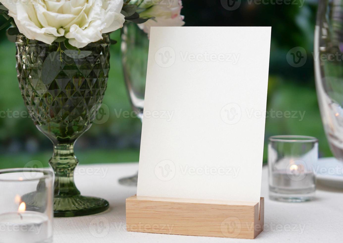 maqueta espacio en blanco blanco para tarjeta de felicitación en el fondo de la mesa de boda. con trazado de recorte foto