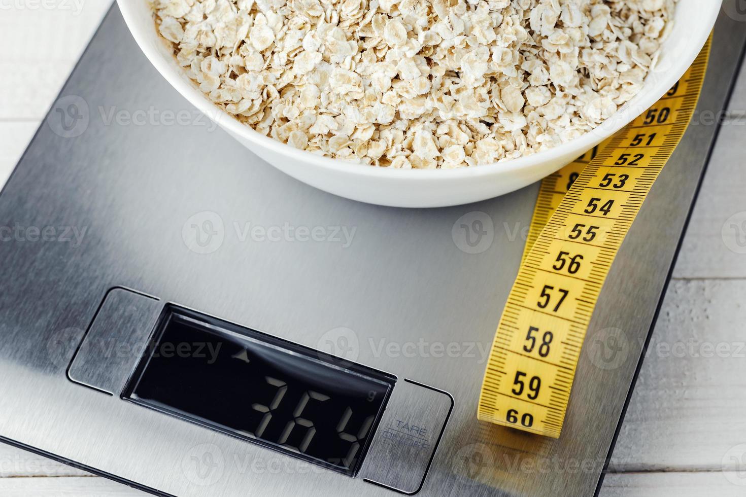 avena en un plato blanco en la báscula de cocina foto