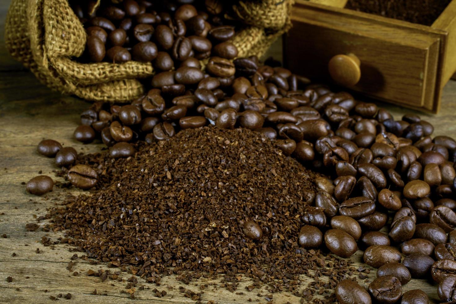 Coffee beans and ground powder  on the old wooden background.soft focus. photo