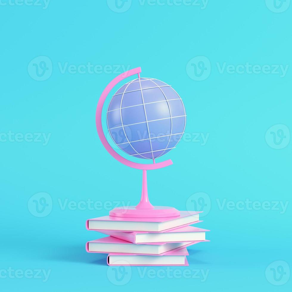 Pink school globe with stack of book on bright blue background in pastel colors photo