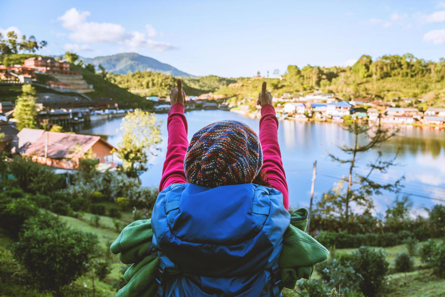 Girl with backpack stand looking forward on beautiful view in lake. Tourist traveler looking sunlight on mountains. Tea plantation in Mae Hong Son. photo