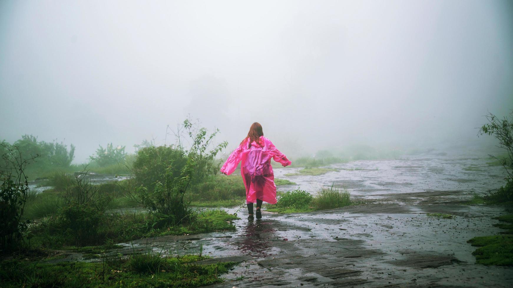 tourist with pink rain coat Stand View the scenery natural beautiful touch fog at Phu Hin Rong Kla National Park. travel nature, Travel relax, Travel Thailand, rainy season. photo