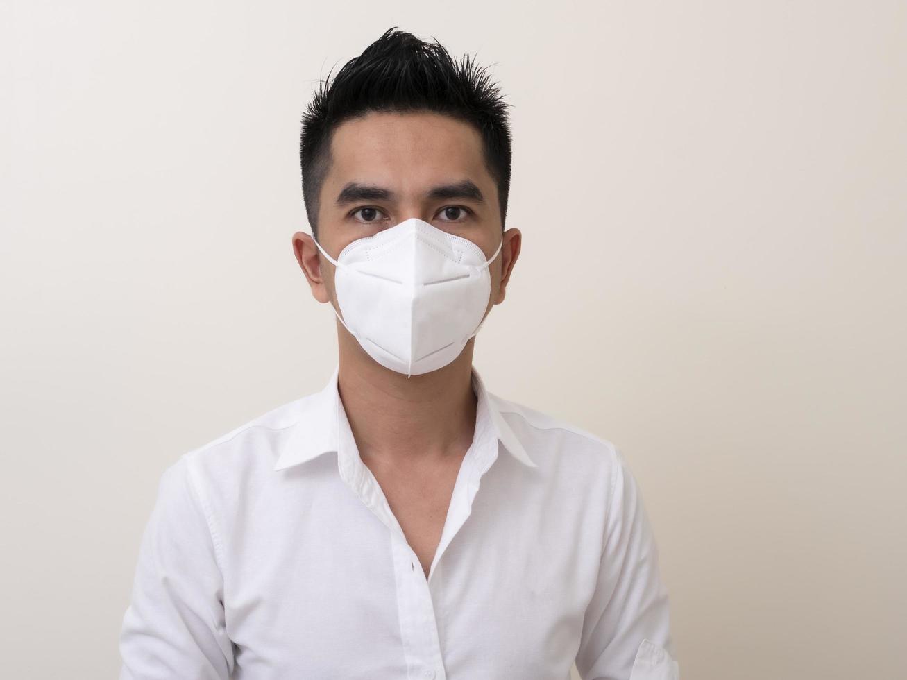 Asian young man in white shirt and medical mask to protect COVID-19 photo