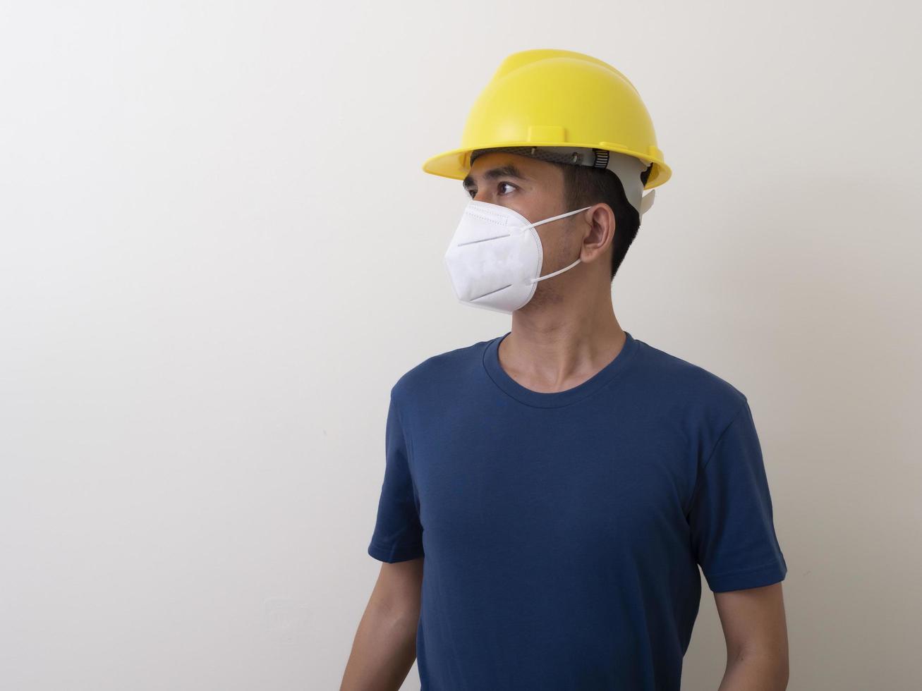 Asian industrial workers wear yellow hard hats, wear protective masks for their healtha photo