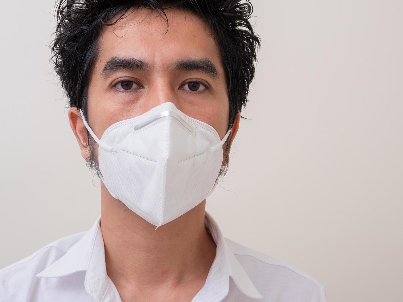 Asian young man in white shirt and medical mask to protect COVID-19 photo