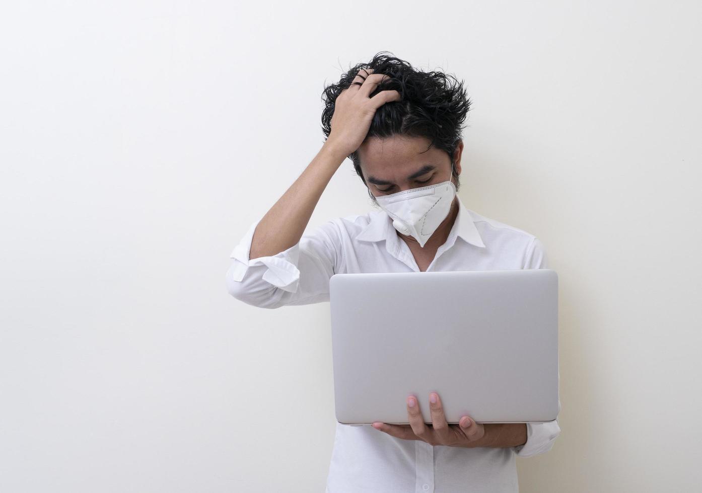 el hombre de negocios con mascarilla médica trabaja en una laptop en casa foto