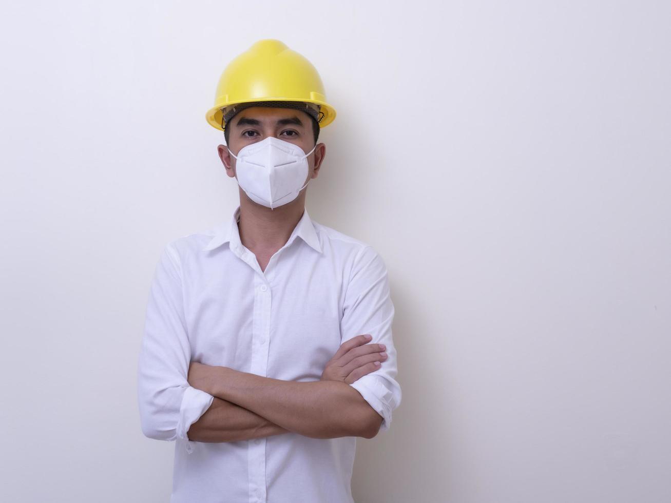 Asian industrial workers wear yellow hard hats, wear protective masks for their health photo