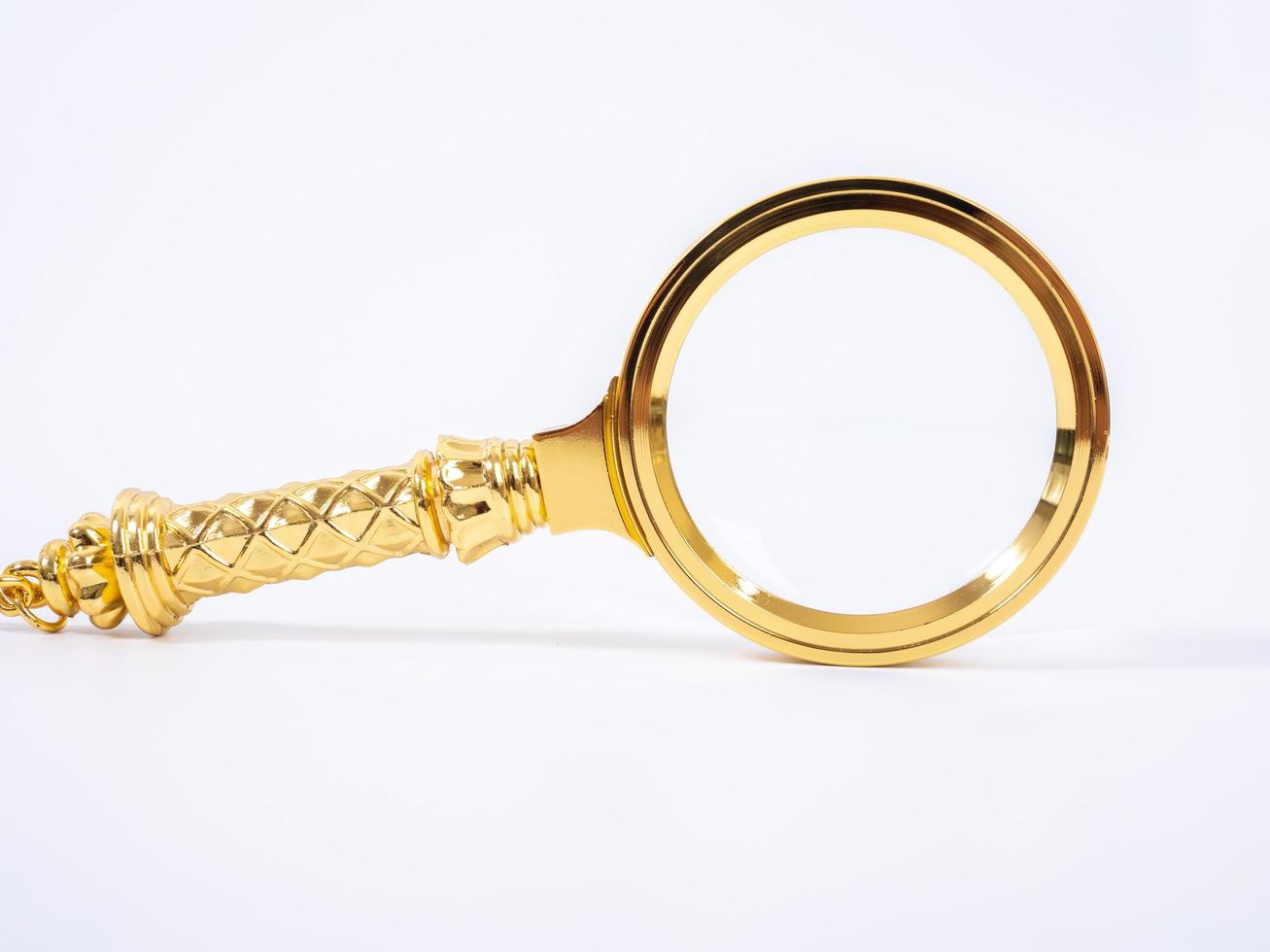 Small Gold Magnifying Glass Isolated on a White Background. photo