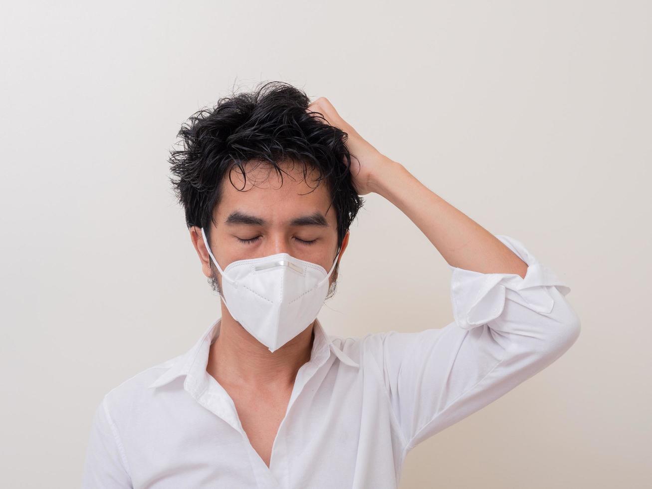 Asian young man in white shirt and medical mask to protect COVID-19 photo