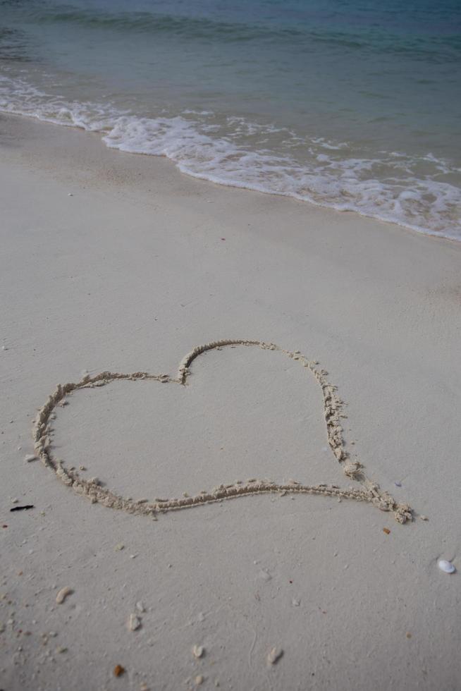 hearts drawn on the sand of a beach photo