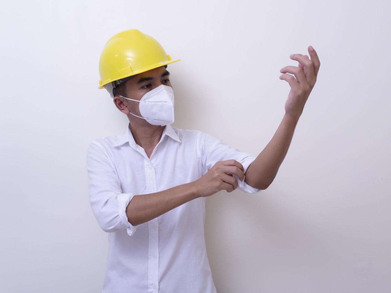 Asian industrial workers wear yellow hard hats, wear protective masks for their health photo