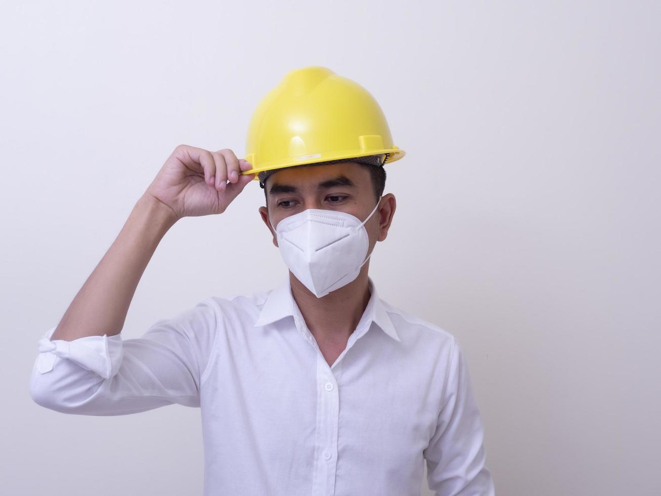 Asian industrial workers wear yellow hard hats, wear protective masks for their health photo