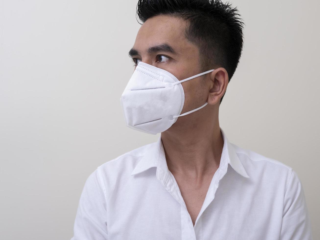 Asian young man in white shirt and medical mask to protect COVID-19 photo