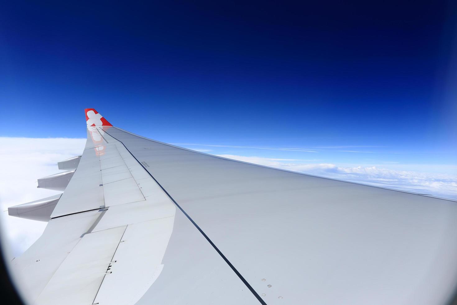 Wing of an airplane flying above the clouds. photo