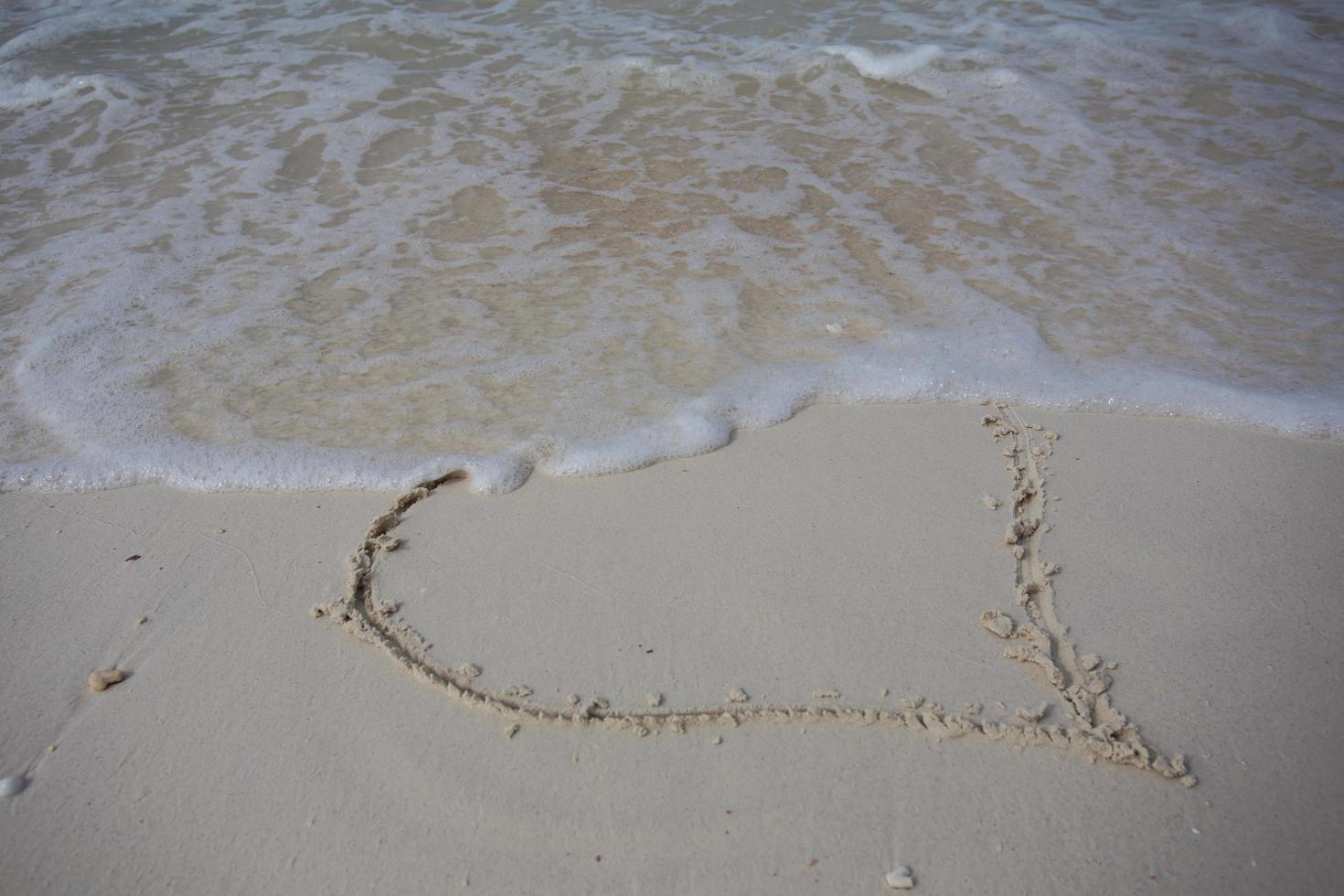 hearts drawn on the sand of a beach photo