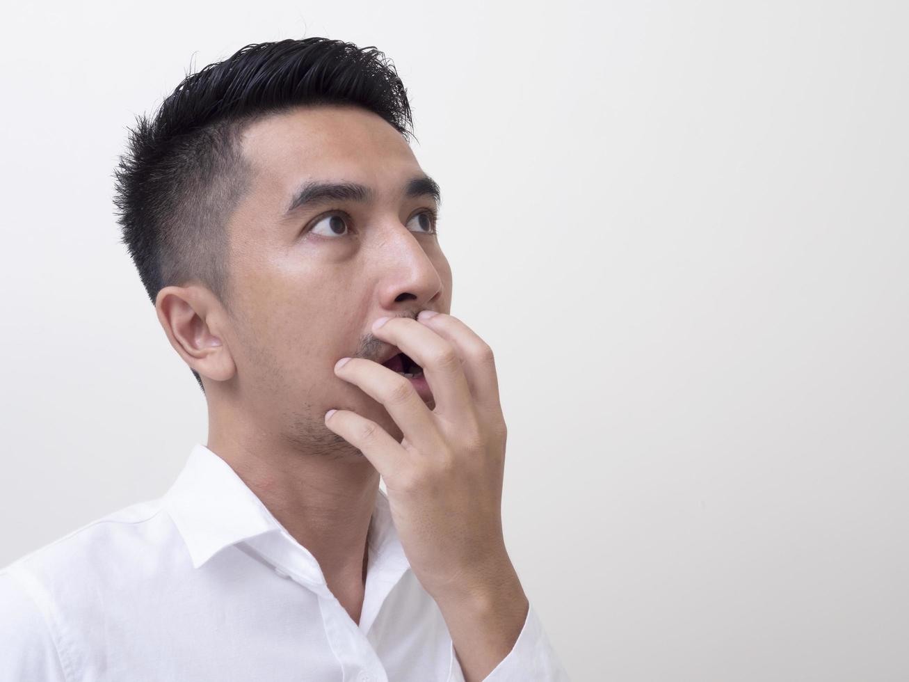 Shocked face of Asian man in white shirt on white background. photo