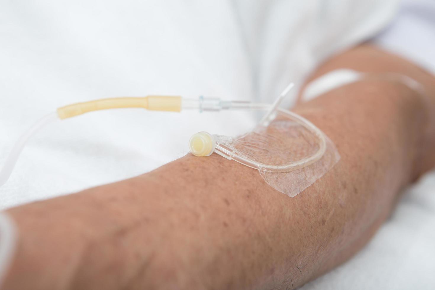 Left hand of the patient on clean bed in the hospital photo