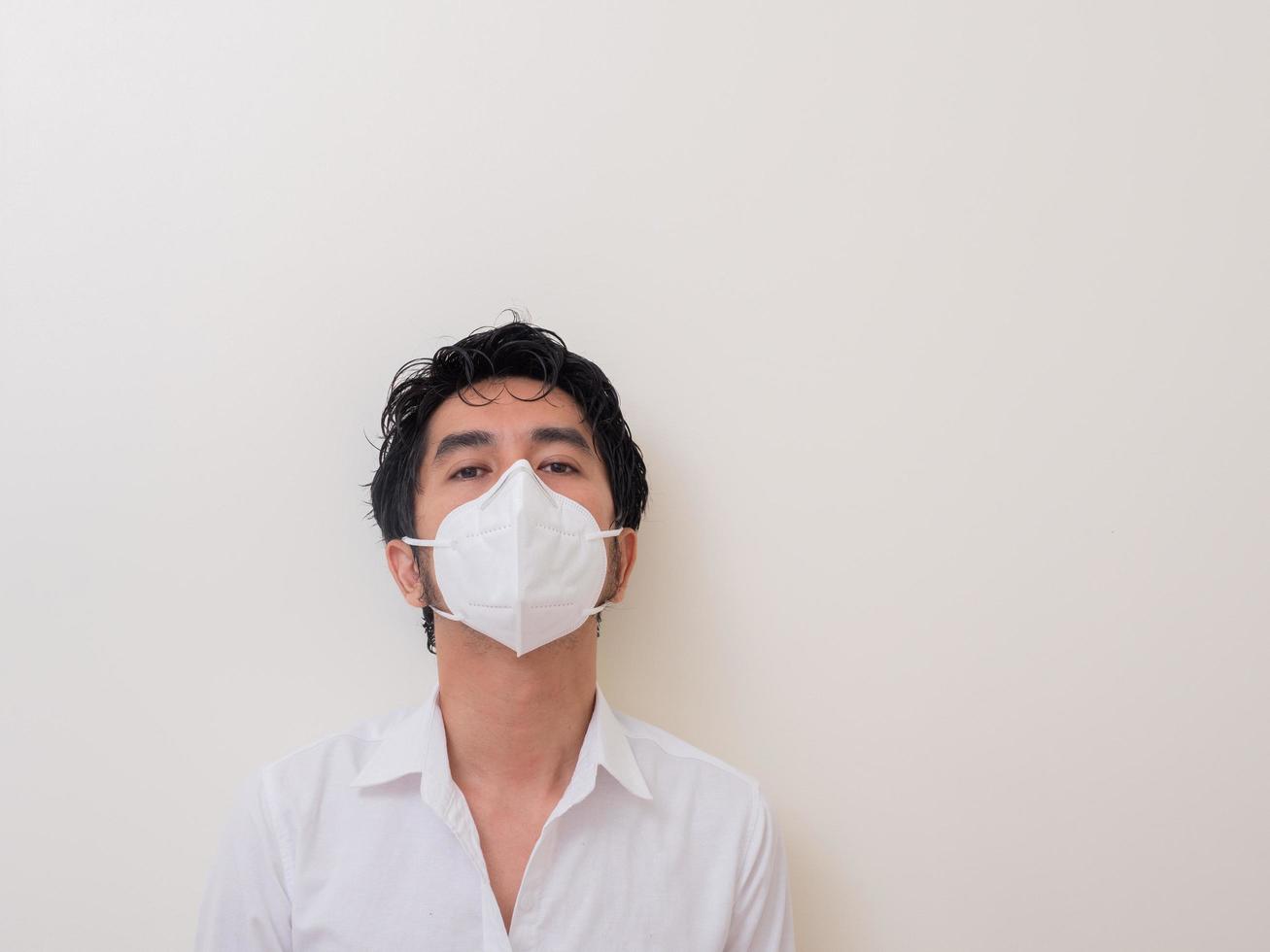 Asian young man in white shirt and medical mask to protect COVID-19 photo