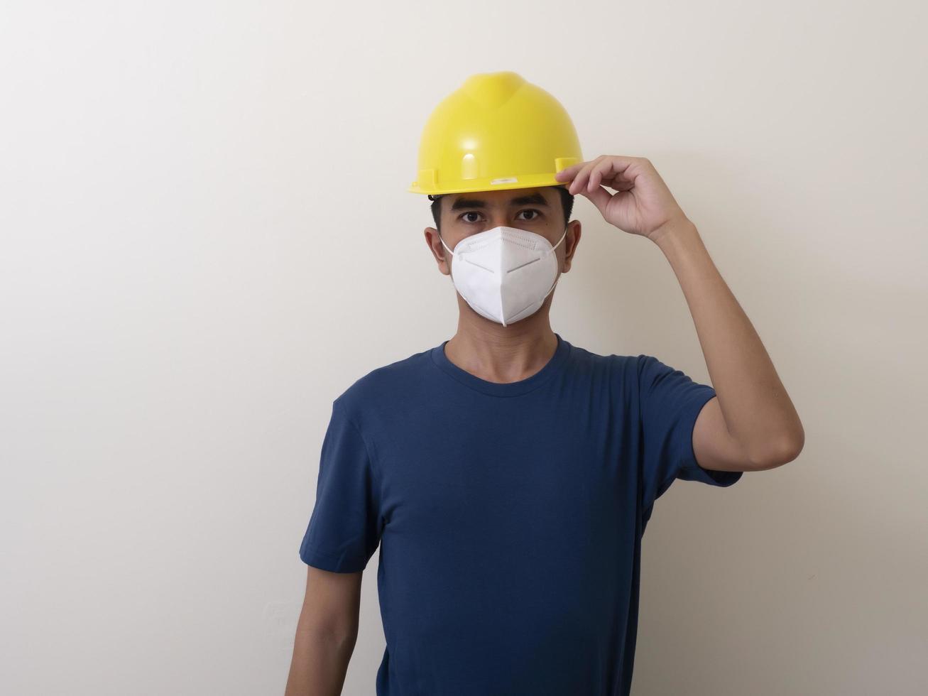 Asian industrial workers wear yellow hard hats, wear protective masks for their health photo