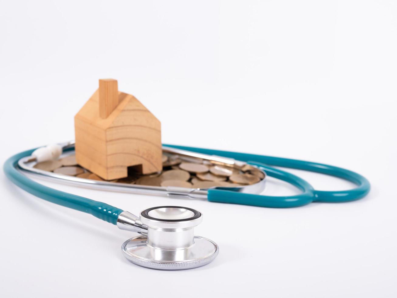 Check up house and investment concept. Stethoscope with miniature house and money photo