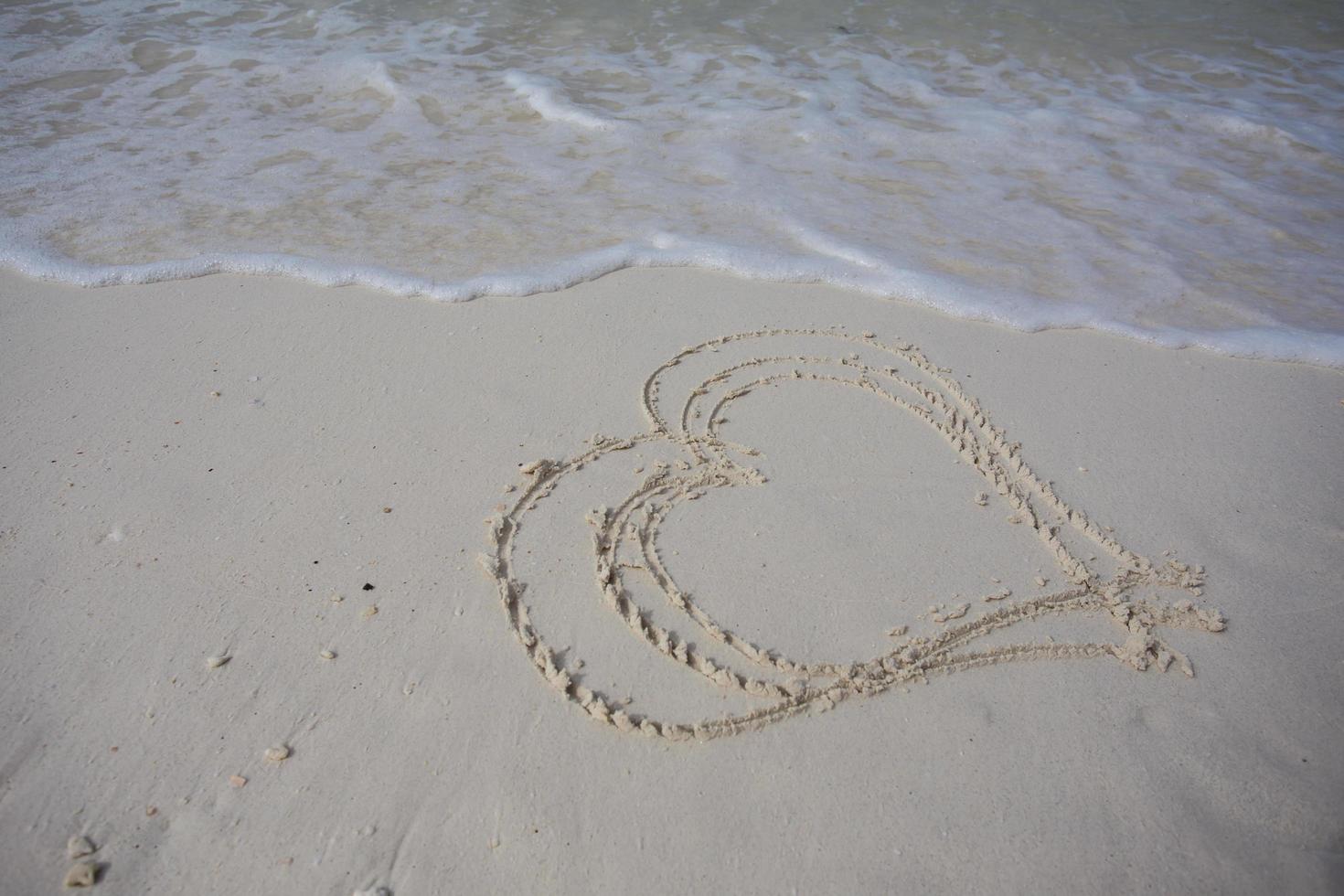 hearts drawn on the sand of a beach photo
