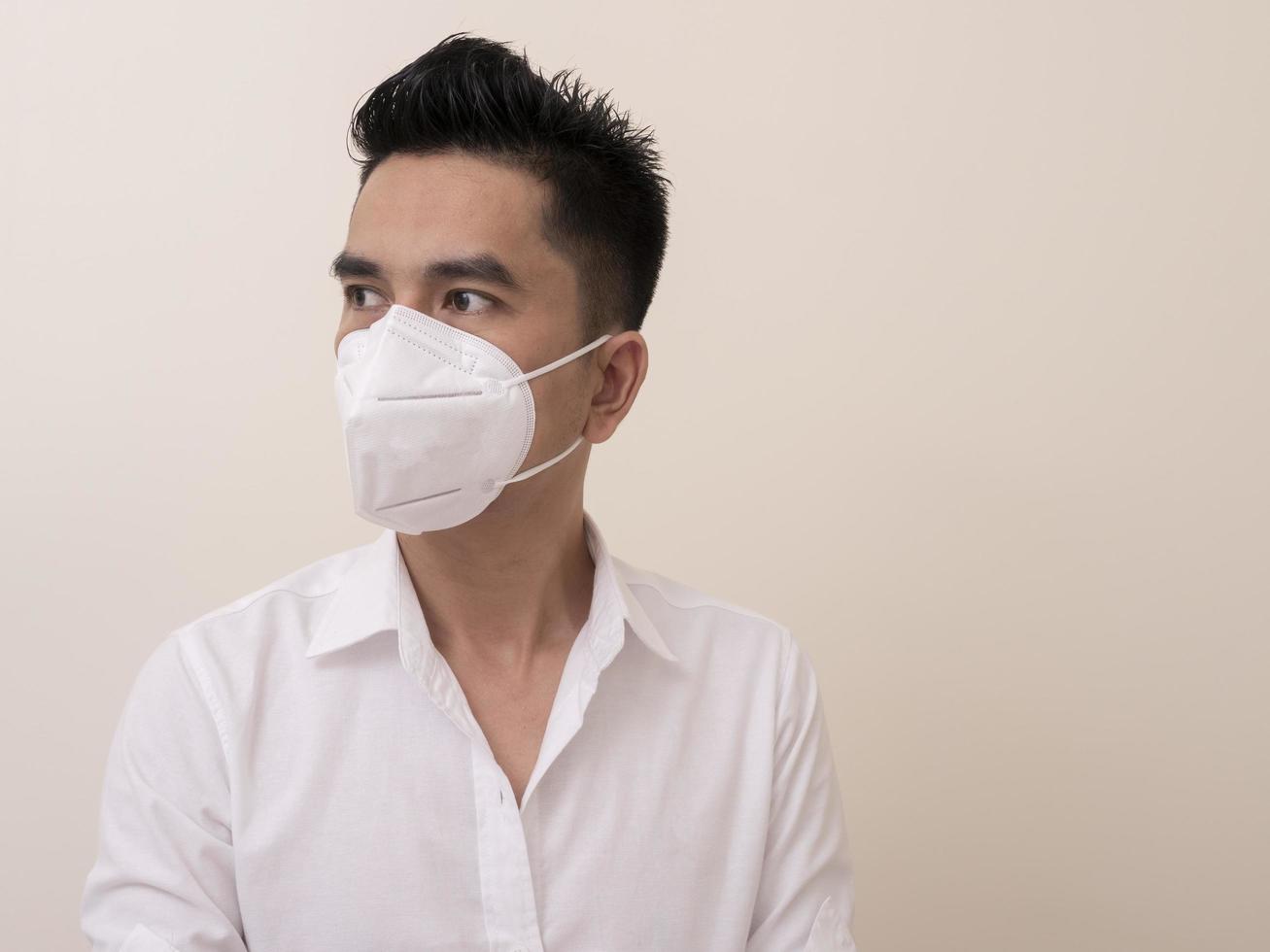 Asian young man in white shirt and medical mask to protect COVID-19 photo