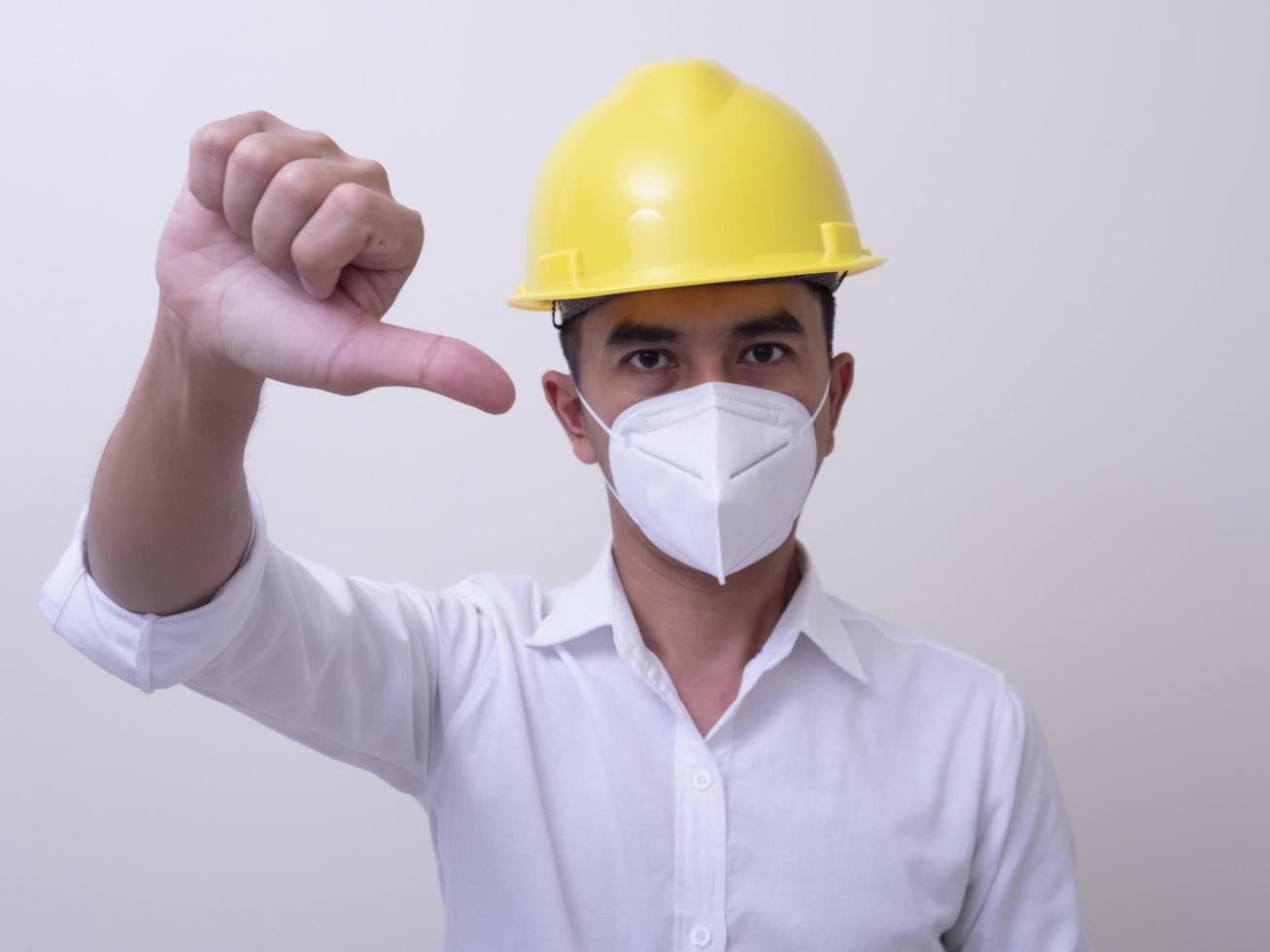Asian industrial workers wear yellow hard hats, wear protective masks for their health photo