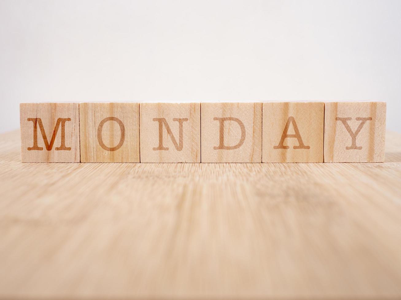 Wooden cube block monday word on blue background photo