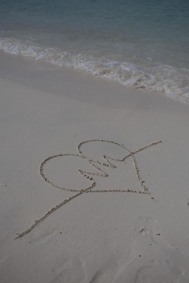 hearts drawn on the sand of a beach photo