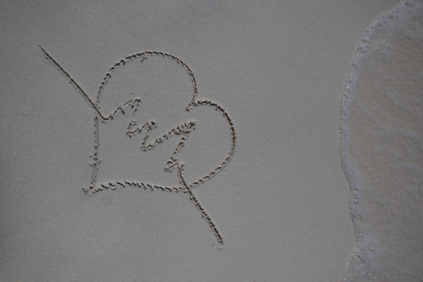 hearts drawn on the sand of a beach photo