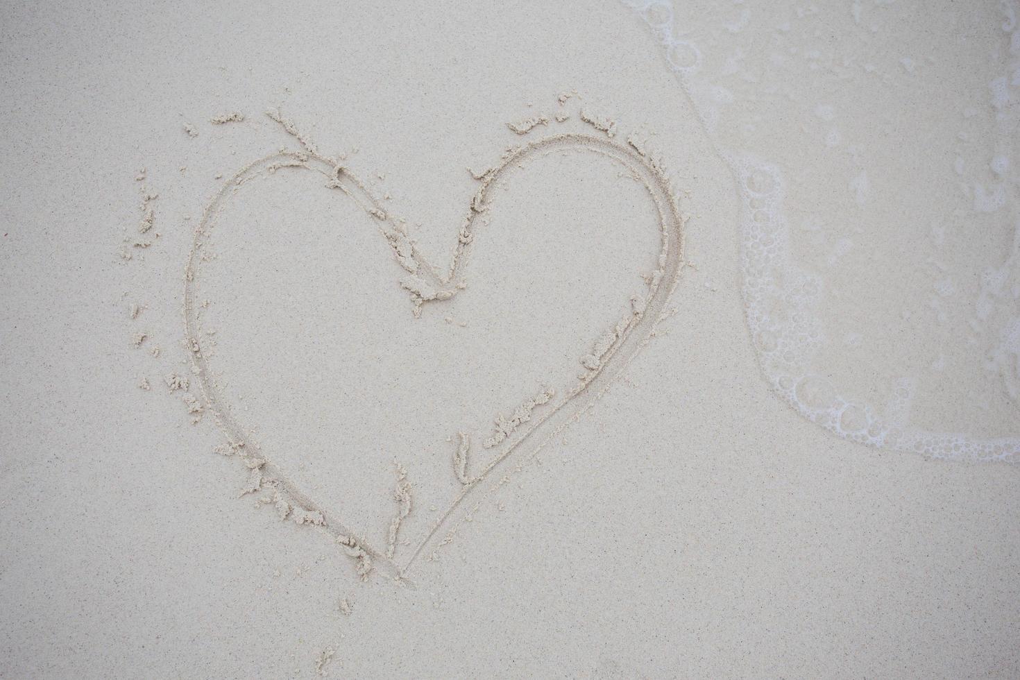 hearts drawn on the sand of a beach photo