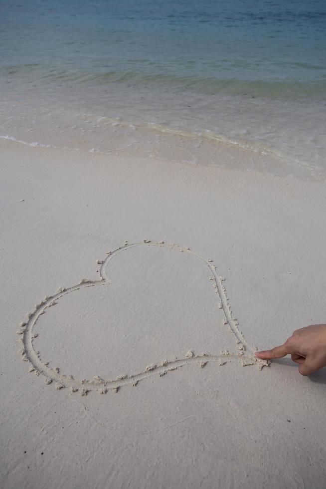 hearts drawn on the sand of a beach photo