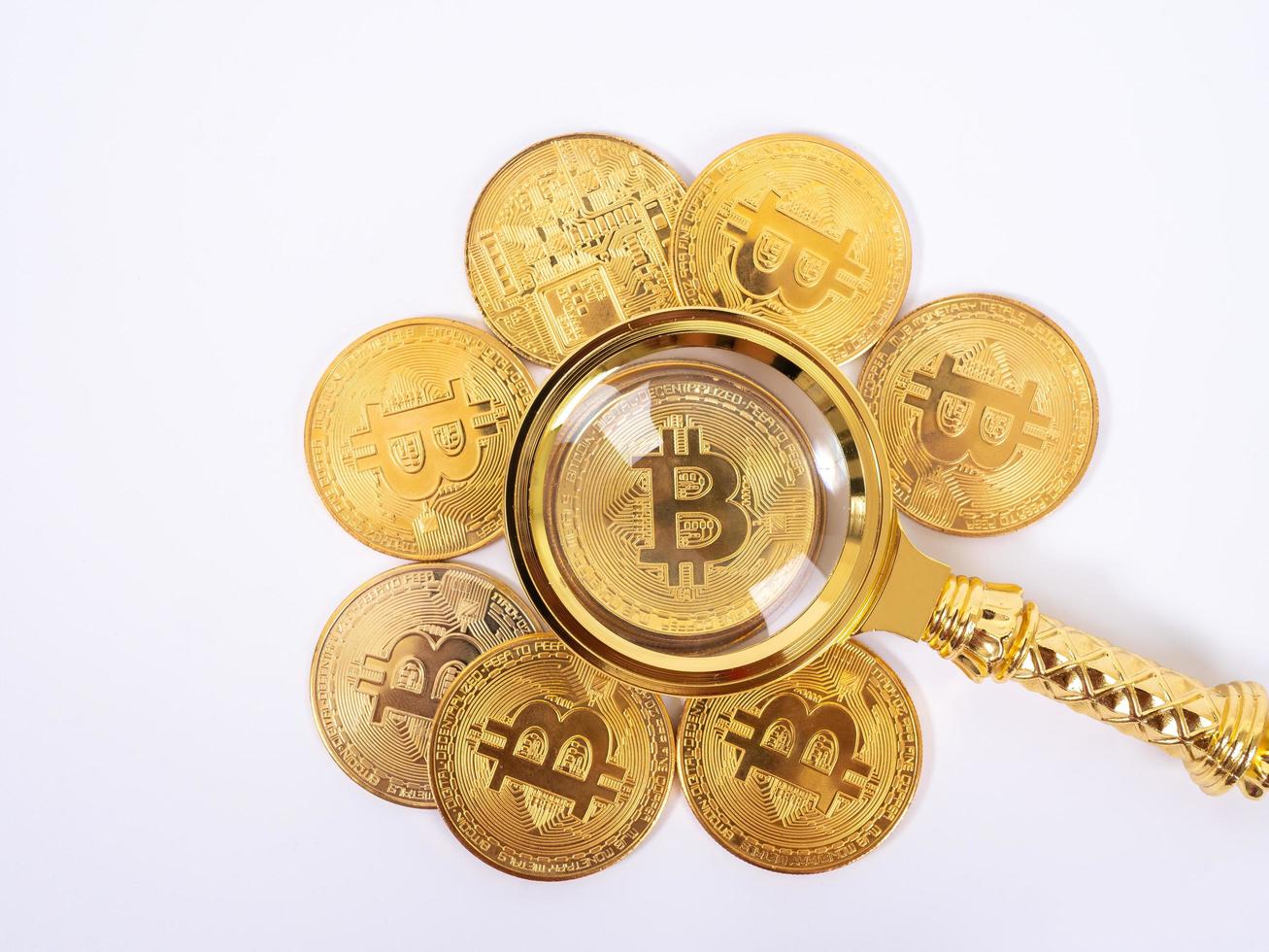 Golden bitcoin magnifying glass on a blurred background of coins photo