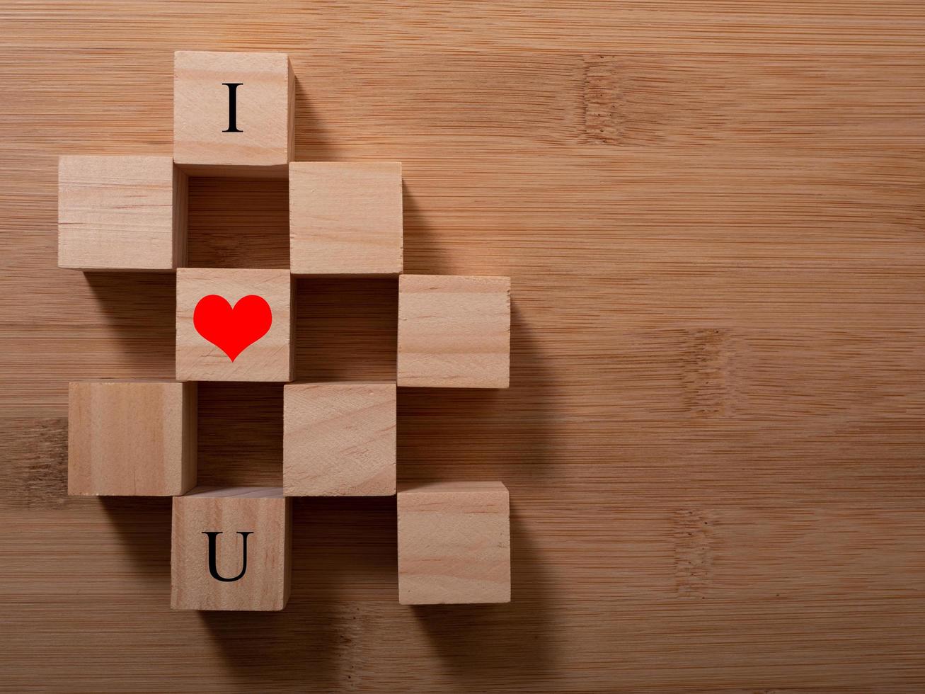 Word Love on wooden cubes with red heart, close-up near white background valentine concept photo