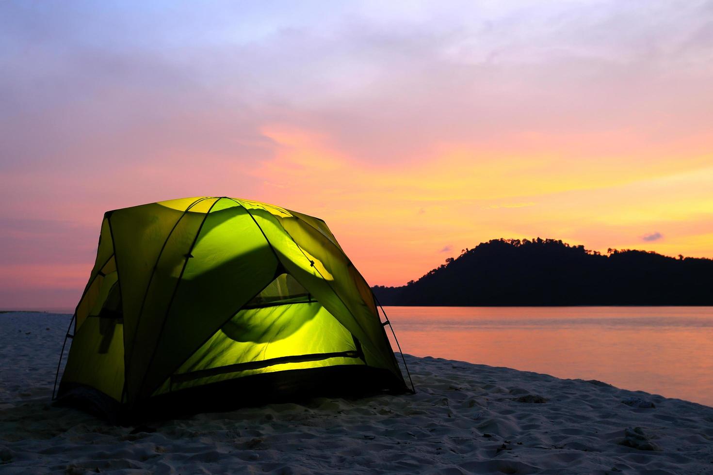 green tent on beach in sunset photo