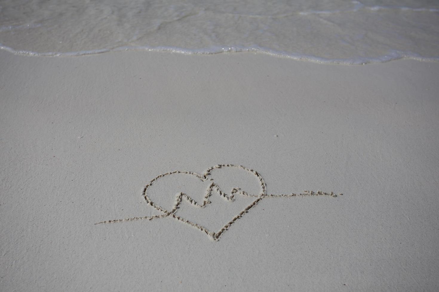 hearts drawn on the sand of a beach photo