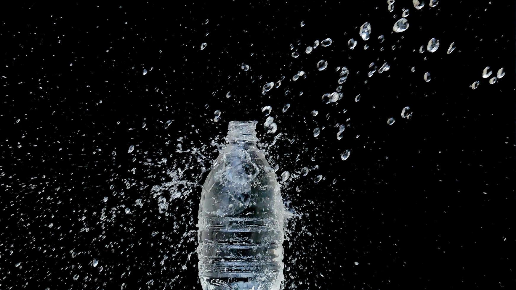 Chorro de agua abstracto se estrella sobre un fondo negro foto