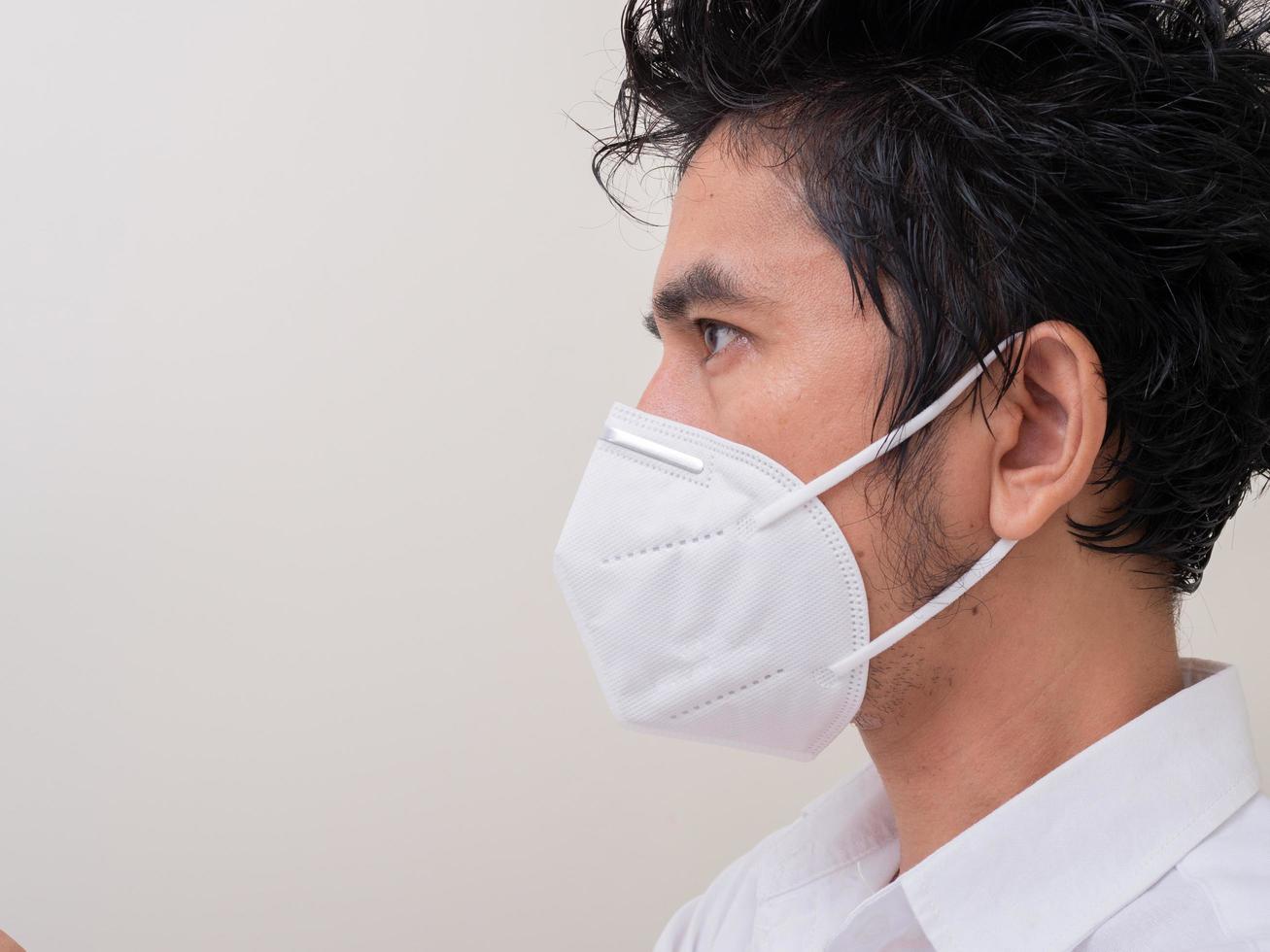 Asian young man in white shirt and medical mask to protect COVID-19 photo